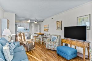 a living room with a blue couch and a tv at OIB34 OIB Isle Retreat in Ocean Isle Beach