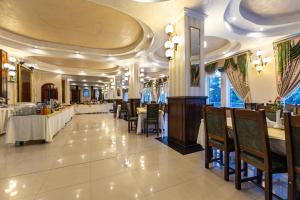 a dining room with tables and chairs in a restaurant at Hotel Golden Spirit in Băile Herculane