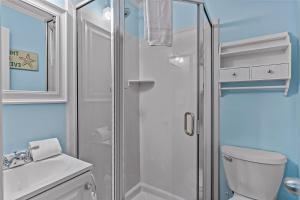 a white bathroom with a shower and a toilet at OIB34 OIB Isle Retreat in Ocean Isle Beach +13 photos