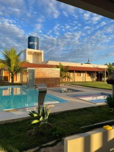 a resort with a swimming pool in front of a building at Pousada Elizium in Montes Claros