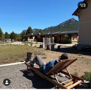 a man laying on a chair in a yard at Complejo Cabañas Ganesh in Lago Meliquina +2 photos