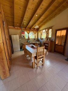 a kitchen with a table and chairs in a room at Complejo Cabañas Ganesh in Lago Meliquina