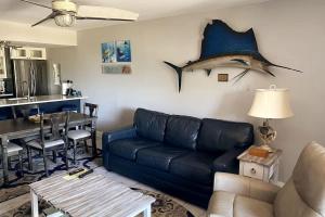 a living room with a blue couch and a table at Stylish Angler's Retreat, Poolside & Ocean Access #16 in Marathon