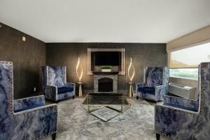 a living room with two blue chairs and a fireplace at Verta Hotel McAllen in McAllen