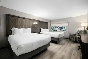 a hotel room with two beds and a desk at Verta Hotel McAllen in McAllen