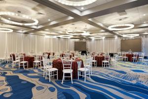 a conference room with tables and chairs and a screen at Verta Hotel McAllen in McAllen