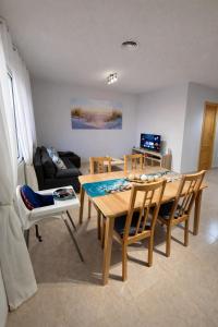 a living room with a table and chairs and a couch at Apartamento Turístico Les Dunes in Els Muntells