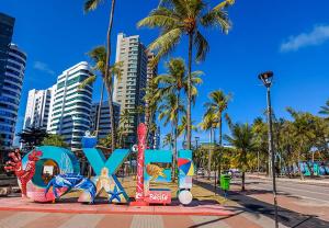 a sign that says love on a street with palm trees at Hospedagem Setúbal in Recife