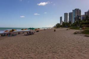 a beach with people sitting under umbrellas and the ocean at Hospedagem Setúbal in Recife +21 photos