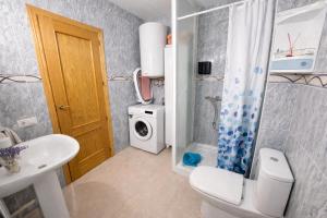 a bathroom with a toilet sink and a washing machine at Apartamento Turístico Les Dunes in Els Muntells +17 photos