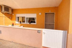 a house with a white fence and a door at Apartamento Turístico Les Dunes in Els Muntells