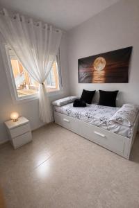 a bedroom with a large bed with a window at Apartamento Turístico Les Dunes in Els Muntells