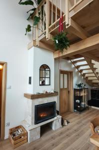 a living room with a fireplace and a staircase at Słonna Chatka in Wujskie