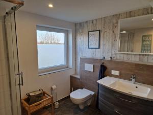 a bathroom with a sink and a toilet and a window at Rettiner Sandbank in Neustadt in Holstein +26 photos