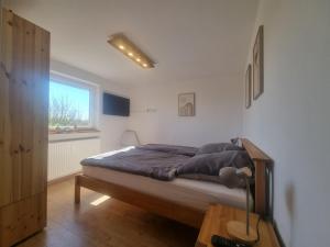 a bedroom with a bed and a window at Rettiner Sandbank in Neustadt in Holstein