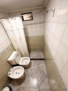 a small bathroom with a toilet and a sink at Complejo turístico Paraíso Escondido in Lago Puelo