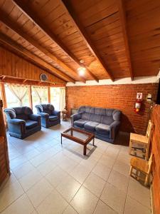 a living room with couches and a brick wall at Complejo turístico Paraíso Escondido in Lago Puelo