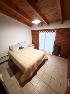 a bedroom with a large bed and a window at Complejo turístico Paraíso Escondido in Lago Puelo