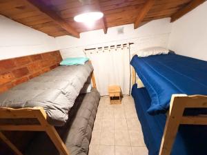 a bedroom with two beds in a room at Complejo turístico Paraíso Escondido in Lago Puelo