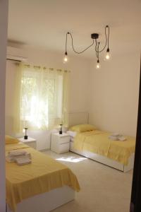 two beds in a room with yellow sheets and lights at Apartment - Pizzo Beach Club in Fondaco Vecchio +15 photos
