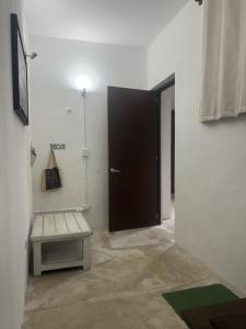 a room with a door and a bench and a table at Casa Azul en Centro de Mérida in Mérida