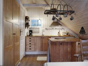 a kitchen with wooden cabinets and a sink at Apartment at Prästtorp in Brastad