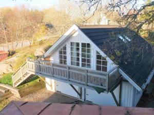 a small white house with a porch and a balcony at Apartment at Prästtorp in Brastad +2 photos
