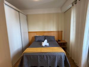 a bed with a teddy bear sitting on top of it at Hotel Flat Biena Parque Ibirapuera 810 incluso estacionamento in São Paulo +24 photos