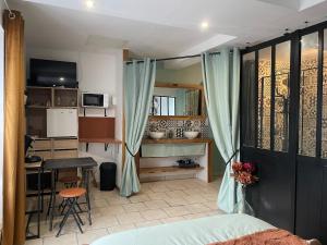 a bedroom with a bed and a table and a kitchen at Le Cosy 8km du futuroscope in Beaumont +17 photos