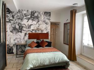 a bedroom with a bed with a floral wallpaper at Le Cosy 8km du futuroscope in Beaumont