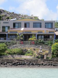 een huis op een heuvel naast het water bij Le Pandanus in Rodrigues Island