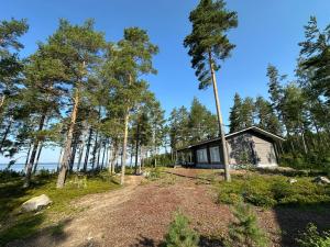 a cabin in the woods with a dirt road in front at Lakeside Cottages in Rastinniemi
