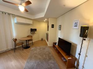 a living room with a table and a flat screen tv at Hotel Flat Biena Parque Ibirapuera 810 incluso estacionamento in São Paulo