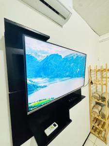 a flat screen tv hanging on a wall at ap 2 quartos com ar e garagem bairro derby in Sobral +2 photos