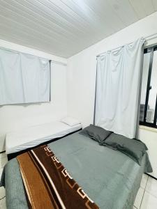 a white room with a bed and a window at ap 2 quartos com ar e garagem bairro derby in Sobral