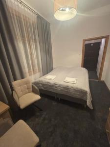 a hotel room with a bed and a chair at Pokoje Gościnne U Niny - Szklarska Poręba in Szklarska Poręba