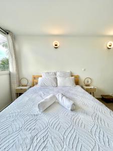 a white bed with two white towels on it at Vue mer sur la Marina, Le Juliana in Pointe-à-Pitre
