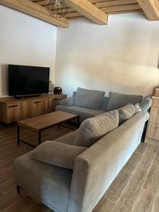 a living room with a couch and a flat screen tv at Chata v Oščadnici - Slniečko in Čadca