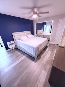 a bedroom with a white bed and a blue wall at The Tel Ft Lauderdale in Fort Lauderdale