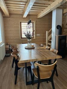 a dining room with a wooden table and chairs at Chata v Oščadnici - Slniečko in Čadca