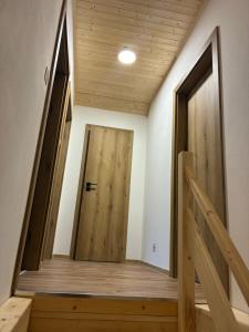 a hallway with a wooden door in a house at Chata v Oščadnici - Slniečko in Čadca