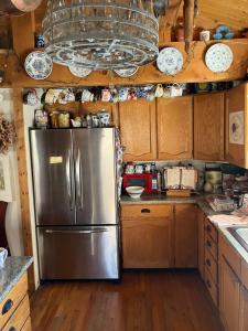 a stainless steel refrigerator in a kitchen with wooden cabinets at The Canyon Wren in Bluff +25 photos