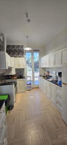 a kitchen with white cabinets and a wooden floor at Dar Alslam hostel in Nizwa