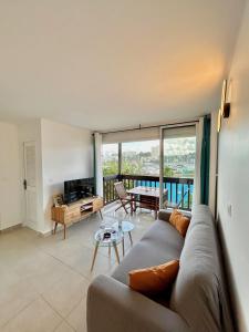 a living room with a couch and a table at Vue mer sur la Marina, Le Juliana in Pointe-à-Pitre