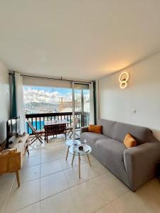 a living room with a couch and a large window at Vue mer sur la Marina, Le Juliana in Pointe-à-Pitre