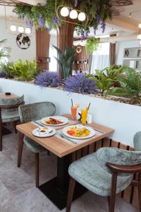 a table with plates of food on it in a restaurant at Amfora Novi Sad in Pasuljište