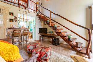 a living room with a wooden spiral staircase at CasinhaPiri in Pirenópolis