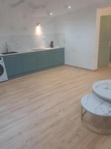 a kitchen with green cabinets and a wooden floor at Aurora in Montauroux