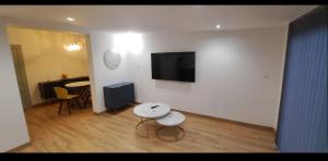 a living room with a table and a tv on a wall at Aurora in Montauroux