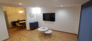 a living room with a table and a tv on a wall at Aurora in Montauroux
